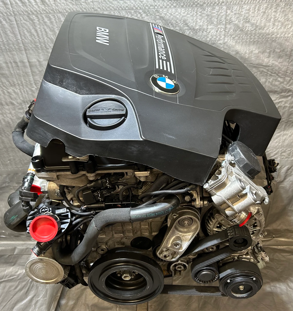 BMW engine with the roundel visible on the rocker cover, stripped and ready to ship
